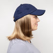 Side view #9441 Classic Wig with Navy Hat shown in (27AH) Dark Strawberry Blonde with Dark Blonde Highlights