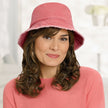 Front view #9503 Distressed Cotton Bucket Hat Shown in Burnt Orange with Shoulder Length Curly Halo (#8059) in (829) Sunkissed Brown